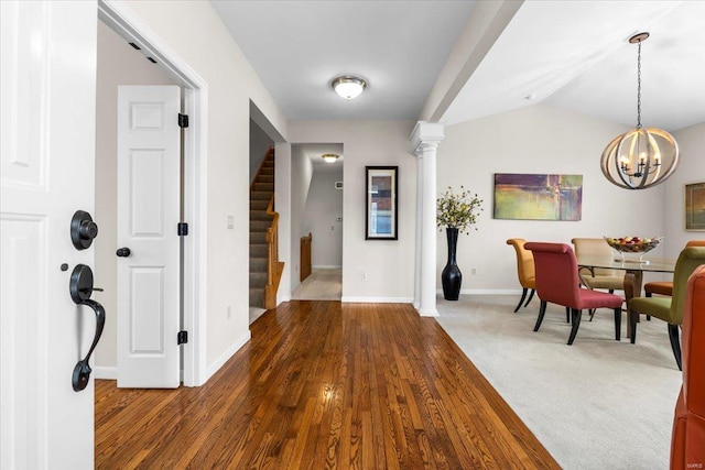 entrance foyer featuring lofted ceiling, wood finished floors, baseboards, stairs, and carpet