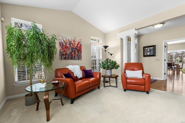 sitting room with decorative columns, baseboards, vaulted ceiling, and carpet flooring