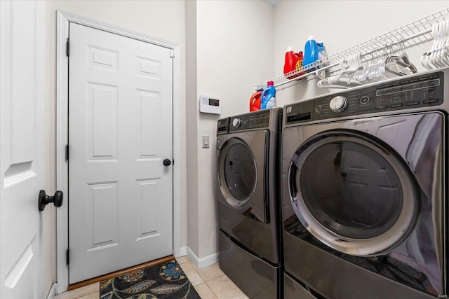 laundry room featuring washer and dryer, laundry area, baseboards, and light tile patterned floors