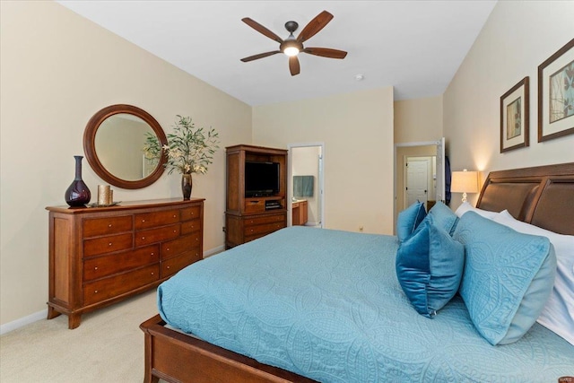 bedroom featuring baseboards, ensuite bath, a ceiling fan, and light colored carpet