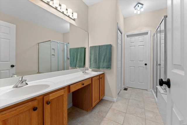 full bath with double vanity, tile patterned flooring, a sink, and a shower stall