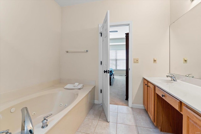 bathroom with a whirlpool tub, tile patterned floors, baseboards, and vanity