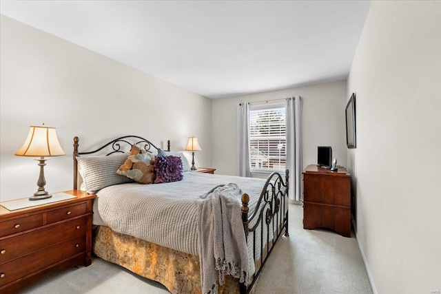 bedroom with light carpet and baseboards