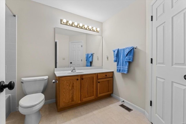 bathroom with toilet, vanity, visible vents, and baseboards