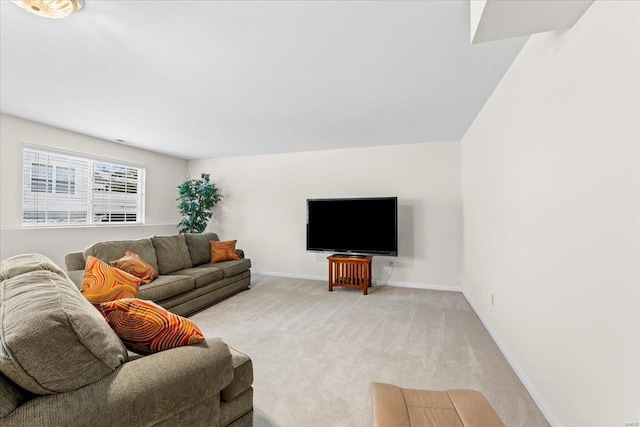 living area featuring light carpet and baseboards