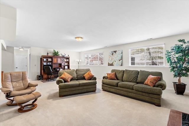 carpeted living area featuring baseboards and a healthy amount of sunlight