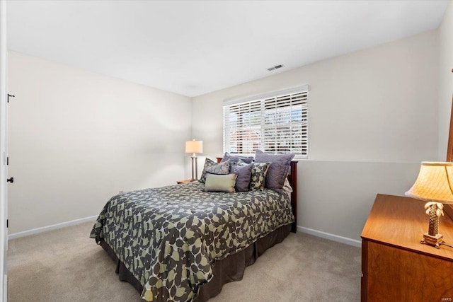 carpeted bedroom featuring visible vents and baseboards