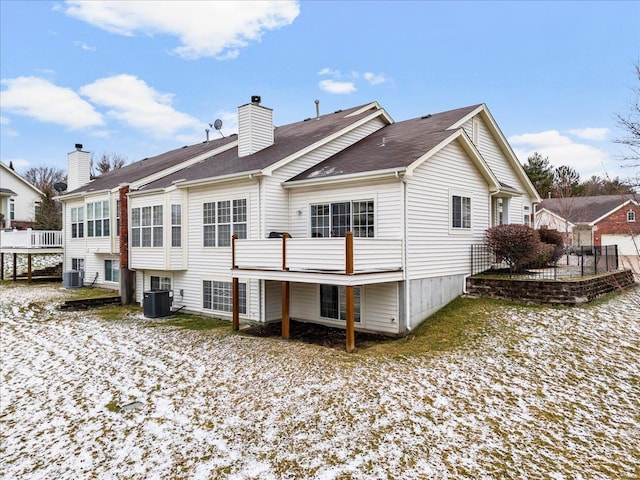 back of property featuring a chimney and central AC