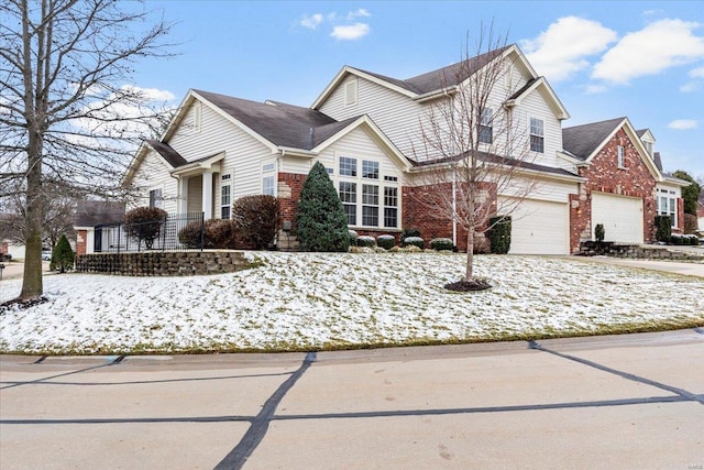 traditional-style house with a garage, concrete driveway, and brick siding