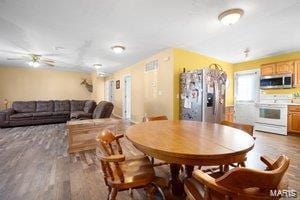 dining space with a ceiling fan and wood finished floors