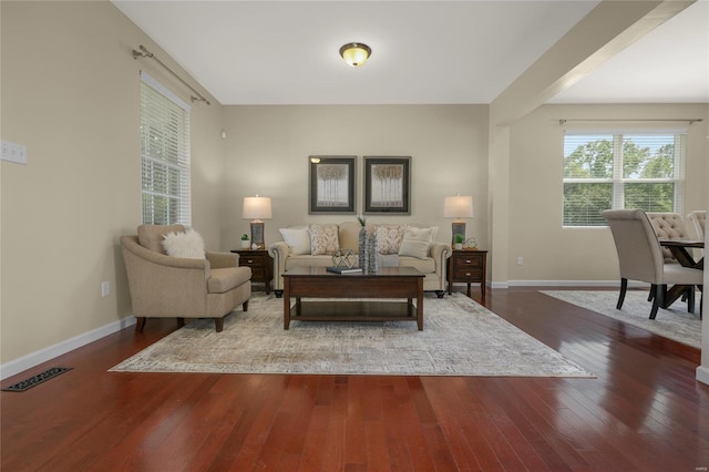 living area featuring baseboards, wood-type flooring, and visible vents