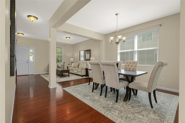 dining space with baseboards, a chandelier, and dark wood-style floors