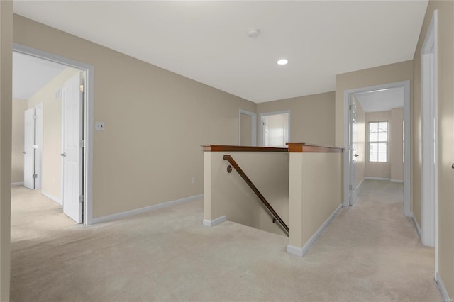 corridor featuring baseboards, light carpet, recessed lighting, and an upstairs landing