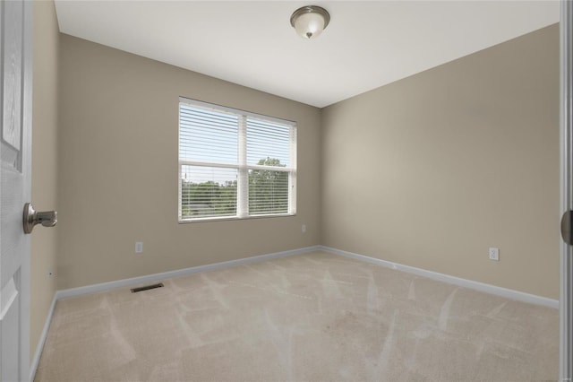 spare room featuring carpet flooring, baseboards, and visible vents