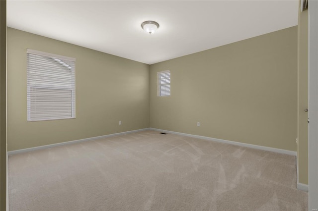 empty room with baseboards and light colored carpet
