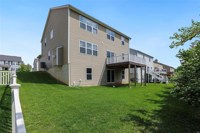 rear view of property featuring a lawn, cooling unit, and a wooden deck