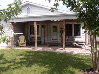 rear view of house with a lawn and a patio area