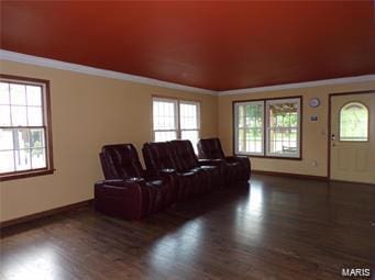 home theater room with crown molding, baseboards, and wood finished floors