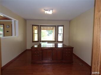 unfurnished office with dark wood-style floors and baseboards