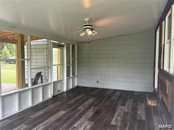 unfurnished sunroom featuring ceiling fan