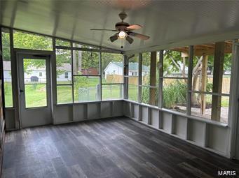 unfurnished sunroom with lofted ceiling and a ceiling fan