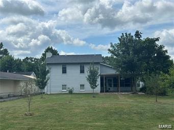 back of house featuring a sunroom and a lawn