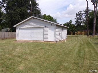 detached garage featuring fence