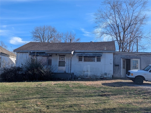 view of front of house with a shingled roof and a front yard