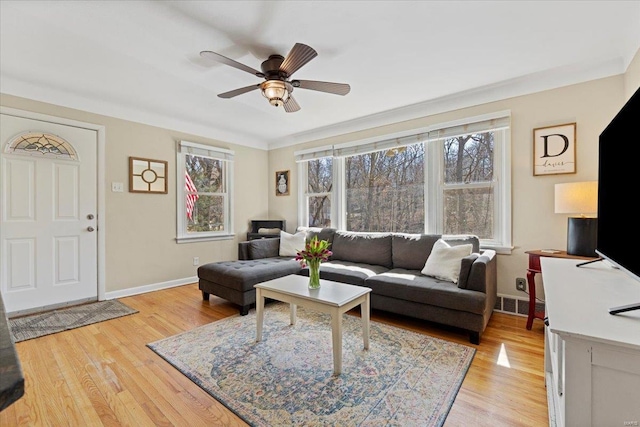 living area featuring light wood-style floors, visible vents, ceiling fan, and baseboards