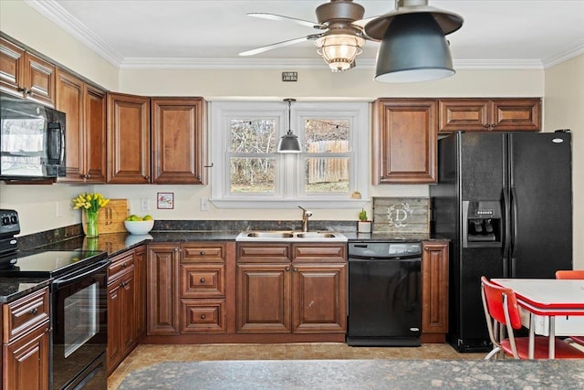 kitchen featuring dark countertops, black appliances, crown molding, and a sink