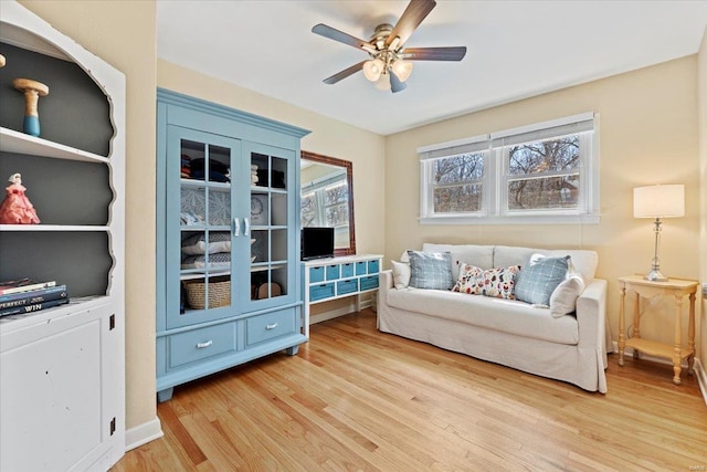 sitting room with ceiling fan and light wood-style flooring