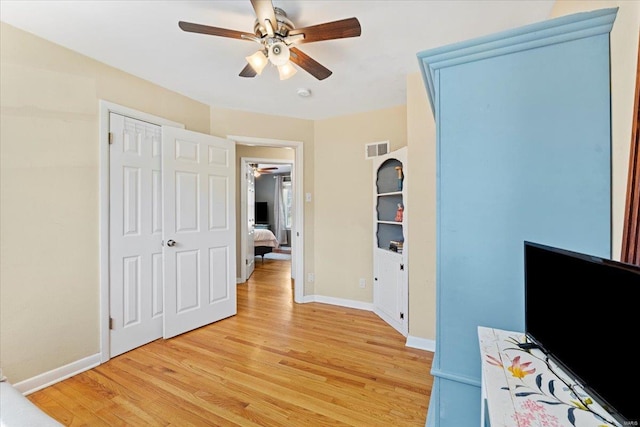 unfurnished bedroom featuring light wood-style floors, baseboards, visible vents, and ceiling fan