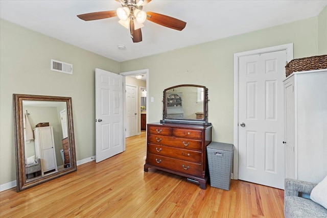 bedroom featuring a ceiling fan, visible vents, light wood-style flooring, and baseboards