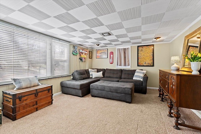 carpeted living room featuring baseboards and crown molding