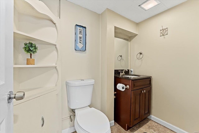 bathroom with toilet, baseboards, and vanity