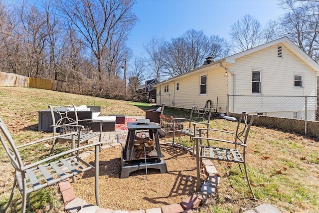 view of yard featuring an outdoor fire pit and fence