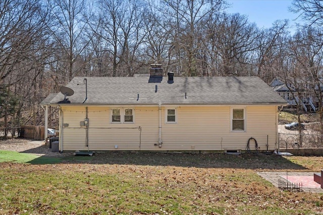 rear view of property with a lawn and fence