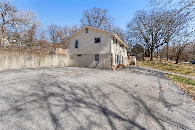 view of side of home with driveway and fence