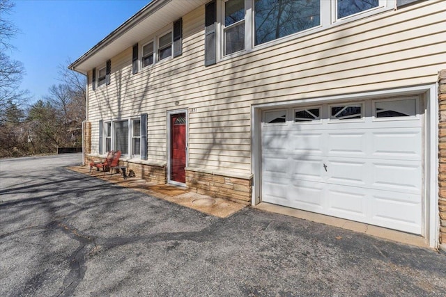 exterior space with aphalt driveway and an attached garage