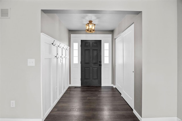 entryway with visible vents, dark wood-type flooring, and a chandelier