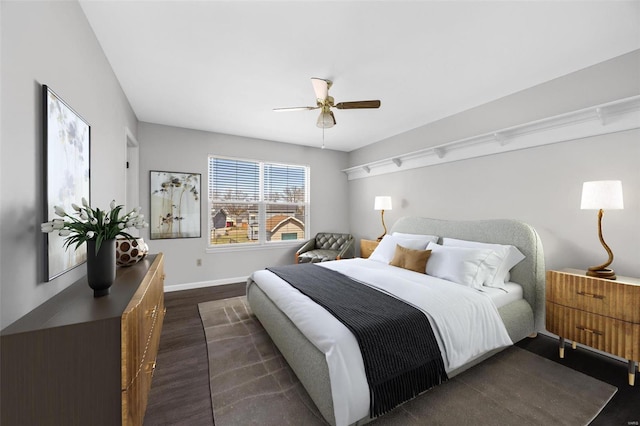 bedroom featuring dark wood-style floors, a ceiling fan, and baseboards