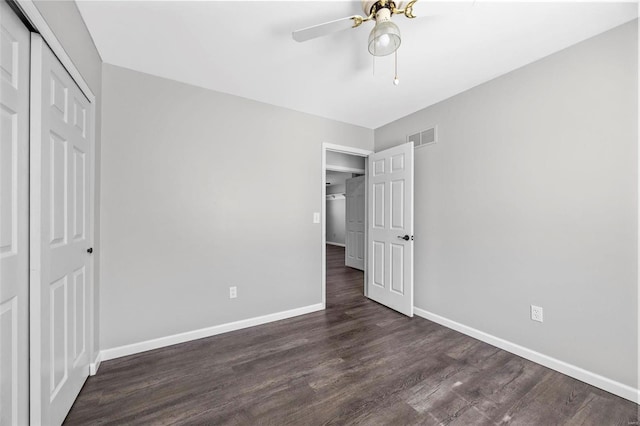 unfurnished bedroom with visible vents, a ceiling fan, dark wood-style floors, a closet, and baseboards