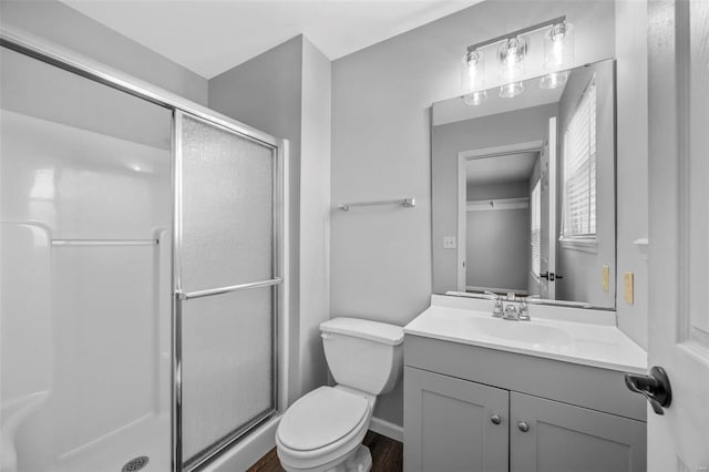 full bathroom with toilet, a stall shower, and vanity