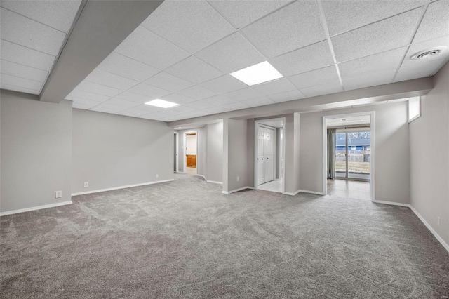 basement with visible vents, carpet, baseboards, and a paneled ceiling