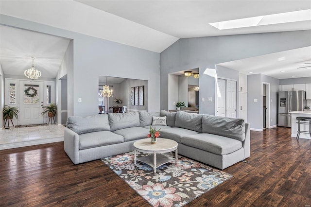 living area with an inviting chandelier, wood finished floors, baseboards, and high vaulted ceiling