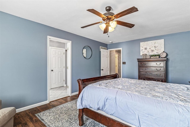 bedroom featuring a ceiling fan, baseboards, and wood finished floors