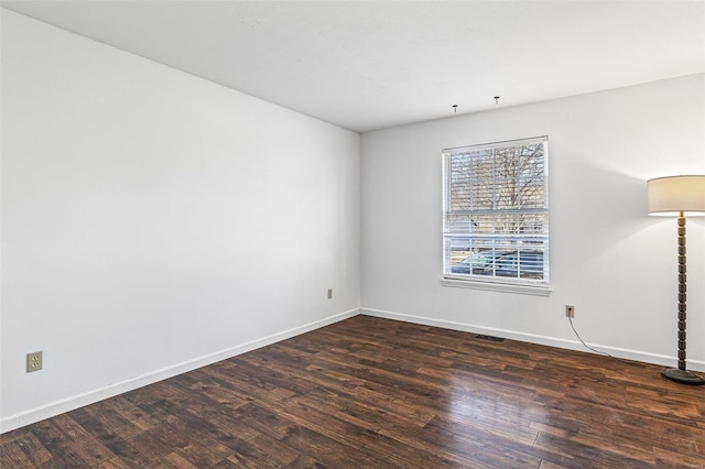 empty room featuring visible vents, baseboards, and wood finished floors