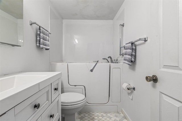 bathroom featuring toilet, vanity, and a tub to relax in