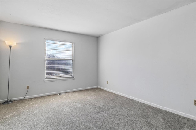 empty room featuring baseboards and carpet floors