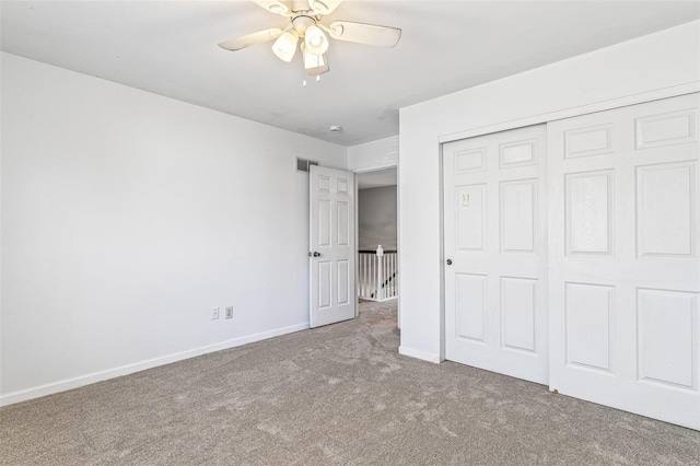 unfurnished bedroom featuring visible vents, a closet, carpet, baseboards, and ceiling fan